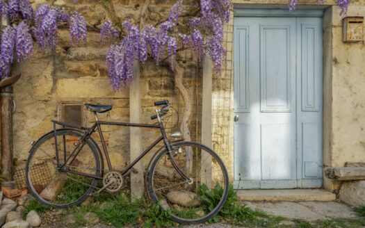 a bicycle parked next to a building with a blue door
