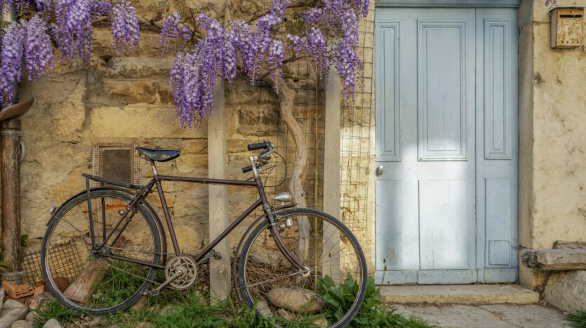 a bicycle parked next to a building with a blue door