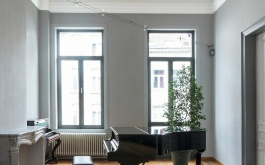black grand piano near window
